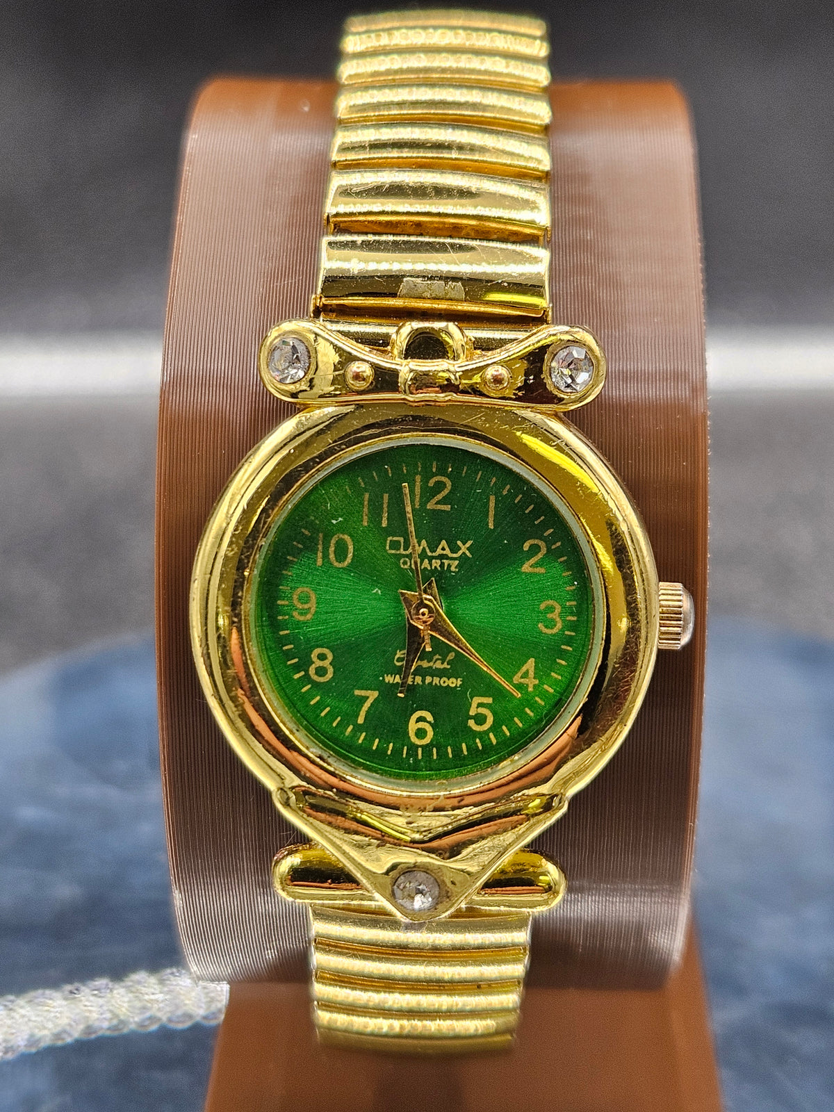 Vintage Womens gold-tone wristwatch features a stretch band and green dial