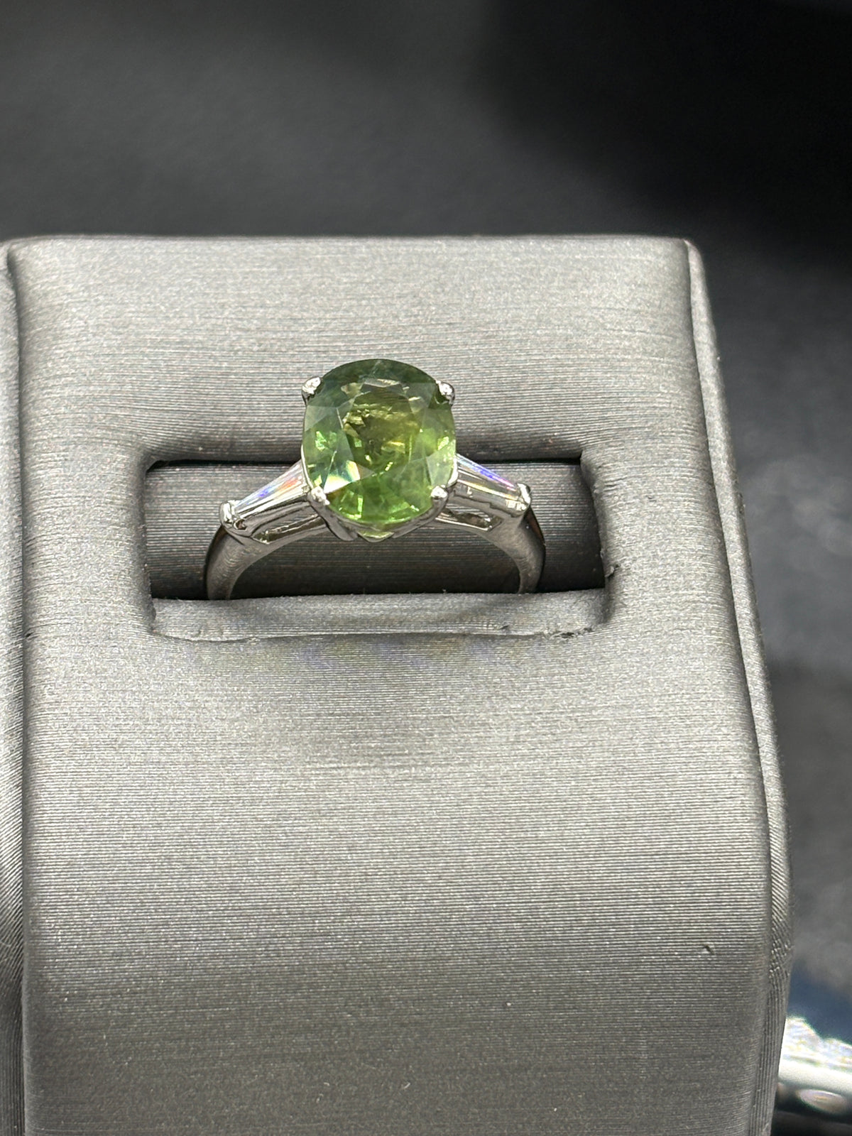 Platinum Oval Green Sapphire with Diamond baguettes set on each side of the Sapphire