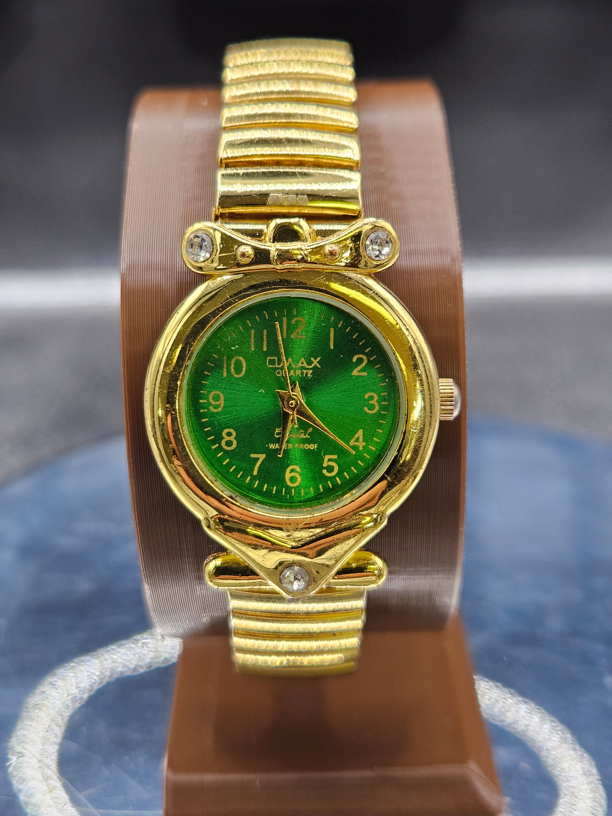 Vintage Womens gold-tone wristwatch features a stretch band and green dial