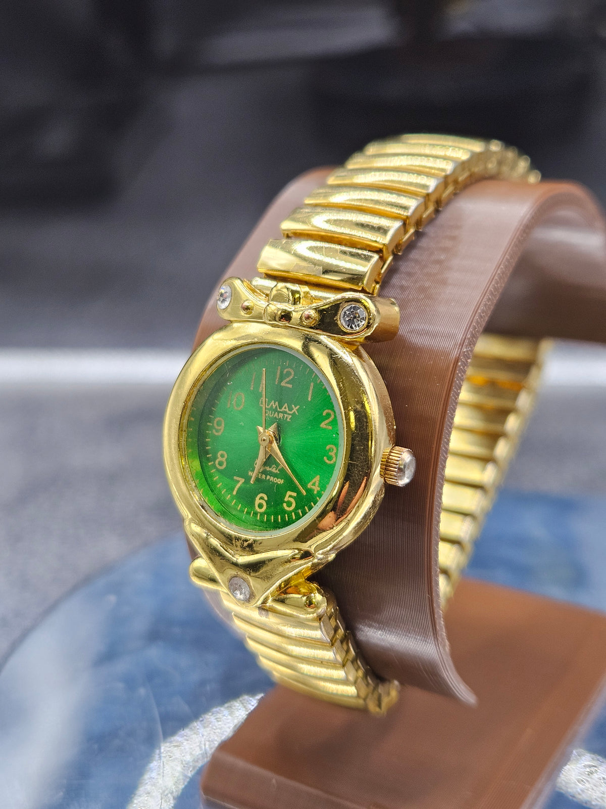 Vintage Womens gold-tone wristwatch features a stretch band and green dial