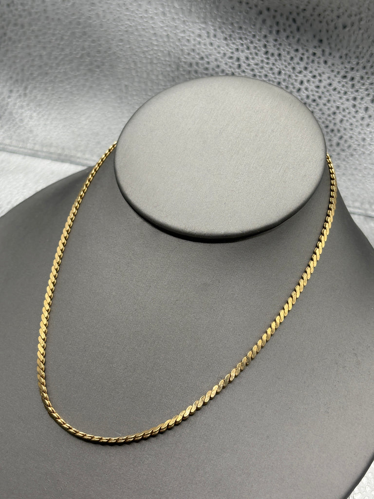 Gold chain on a gray mannequin bust