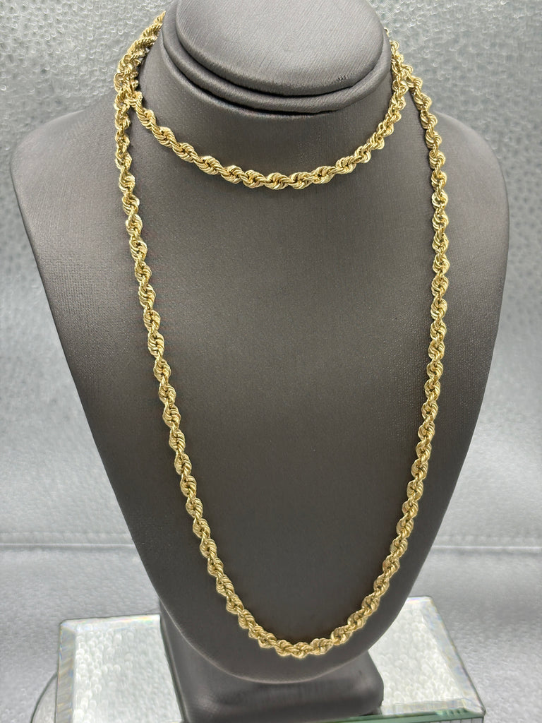 Gold chain on a gray jewelry display