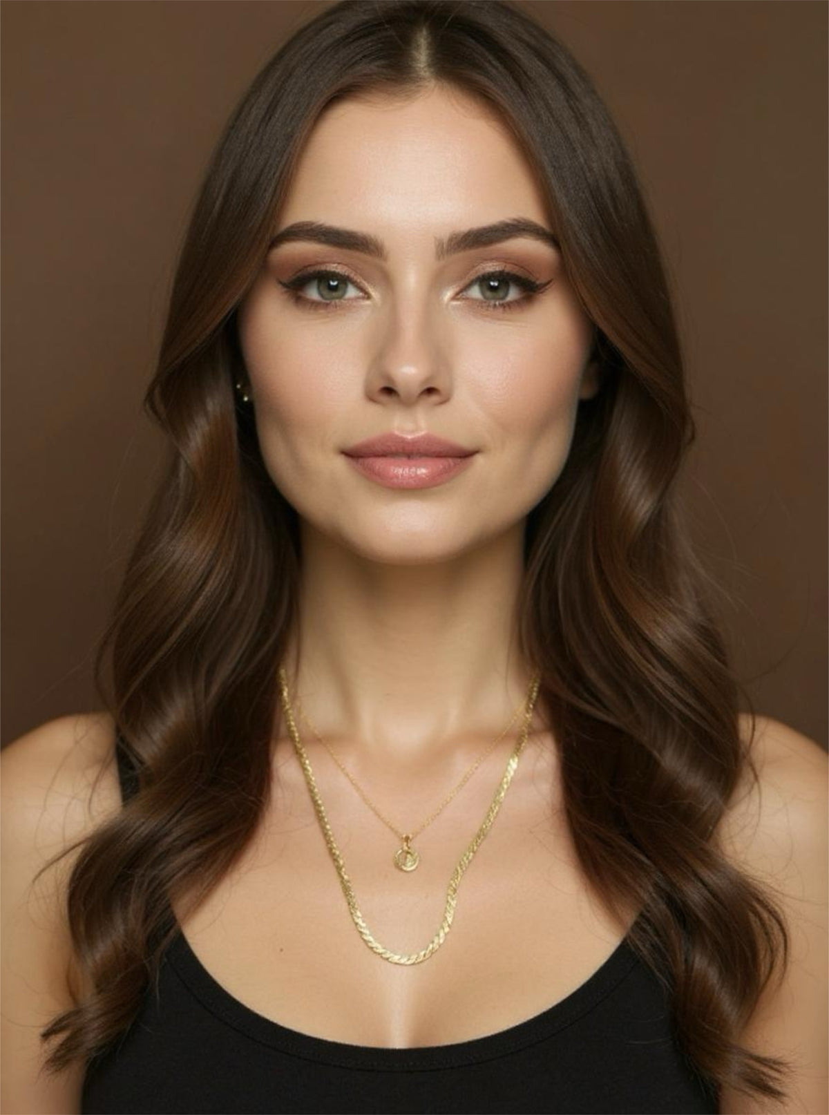 Woman wearing a gold necklace against a brown background