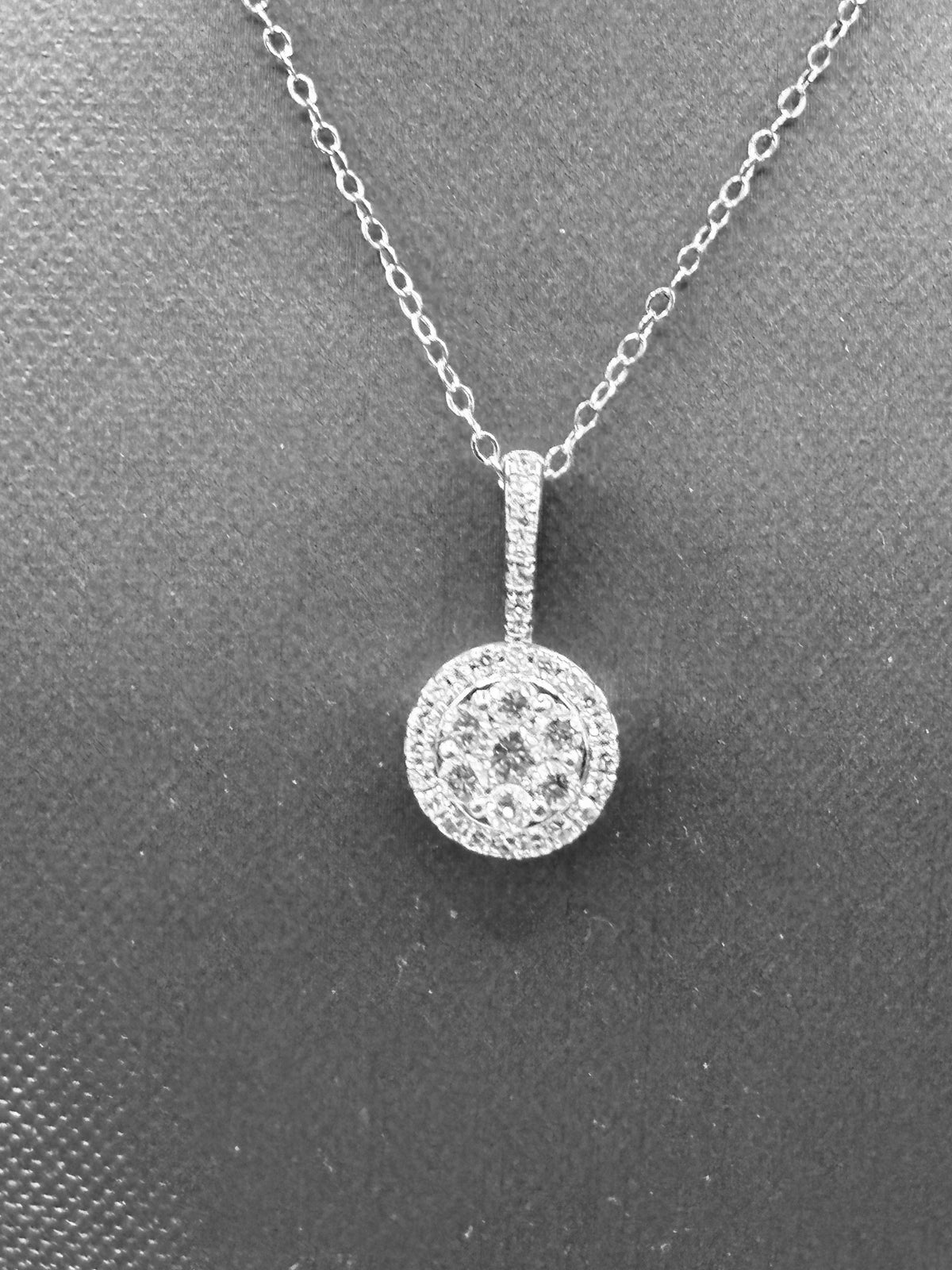 14kt solid white gold,  ladies diamond cluster pendant with diamond halo and diamond bale, hanging from a 16’’ pendant chain
