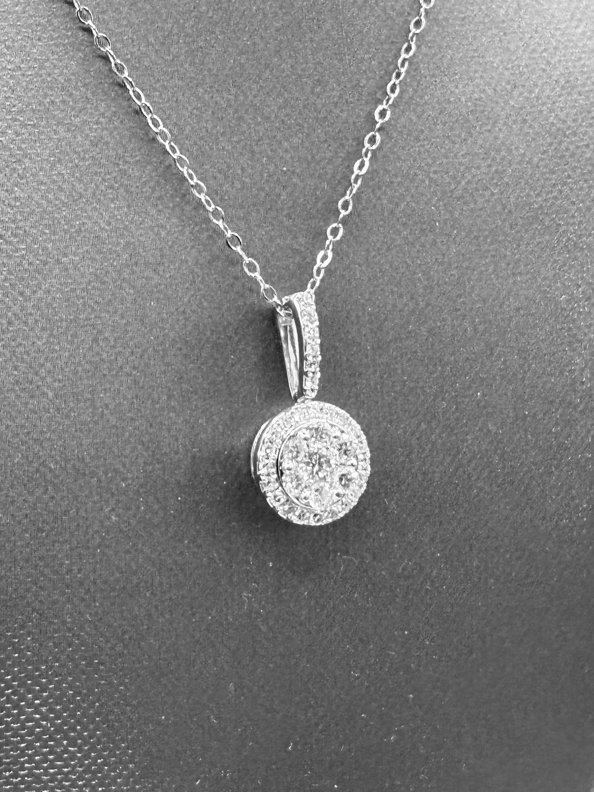 14kt solid white gold,  ladies diamond cluster pendant with diamond halo and diamond bale, hanging from a 16’’ pendant chain