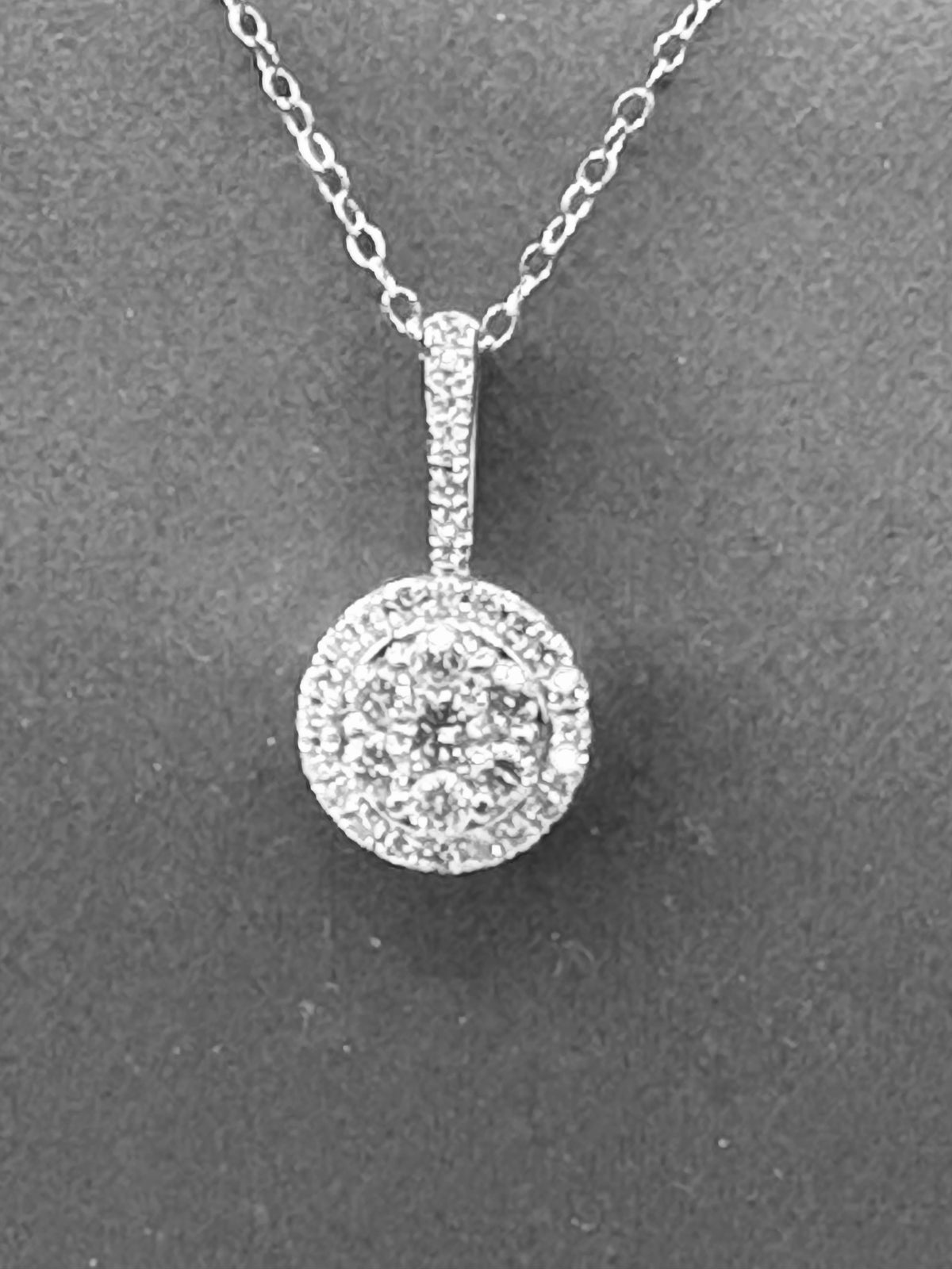 14kt solid white gold,  ladies diamond cluster pendant with diamond halo and diamond bale, hanging from a 16’’ pendant chain