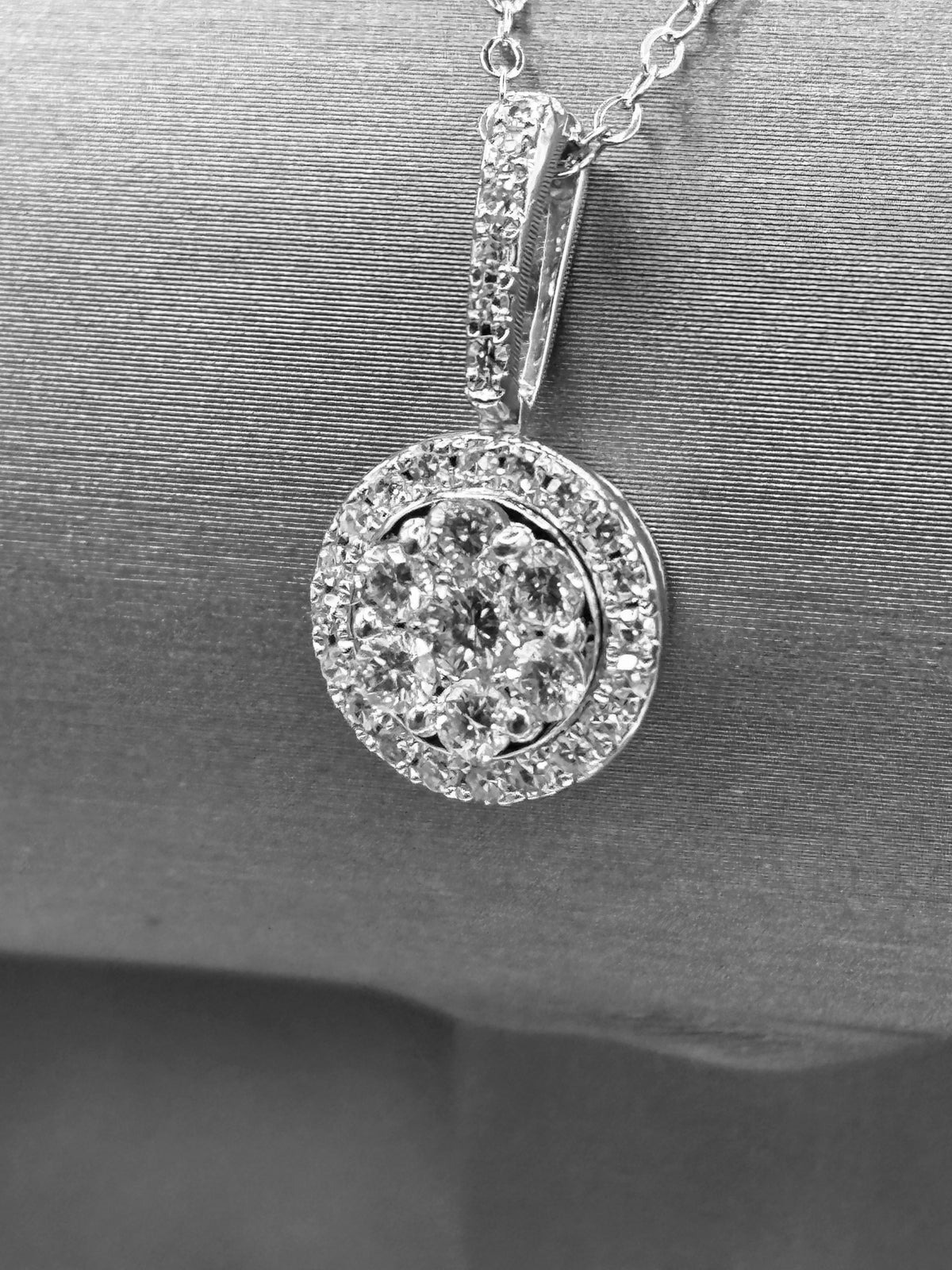 14kt solid white gold,  ladies diamond cluster pendant with diamond halo and diamond bale, hanging from a 16’’ pendant chain