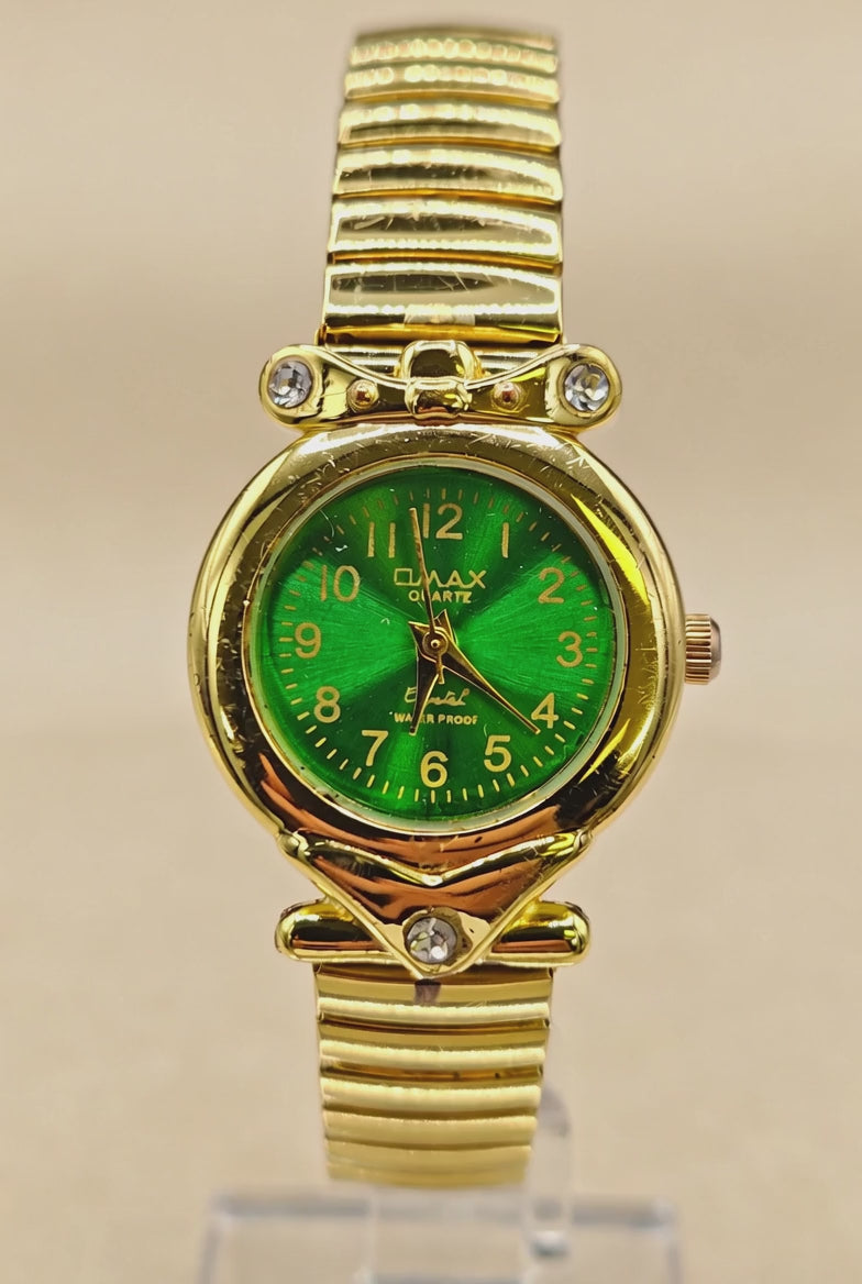 Vintage Womens gold-tone wristwatch features a stretch band and green dial