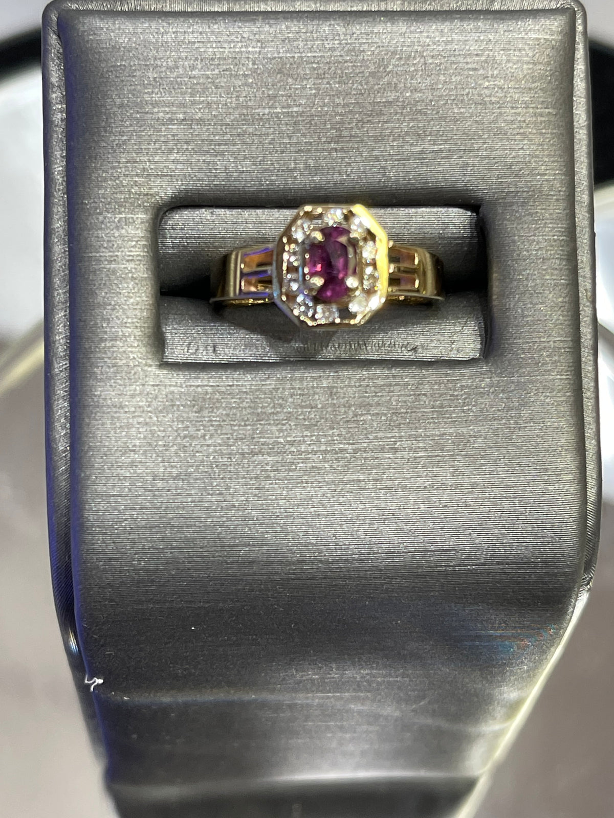 A 14KT yellow gold ruby and diamond ring with a halo surround.